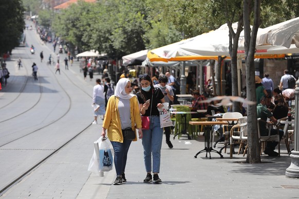 epa08446992 People walk next to a cafe in Jerusalem, 27 May 2020. Media report that Israel has officially opened restaurants and cafes that were closed for more than two months in order to prevent the ...