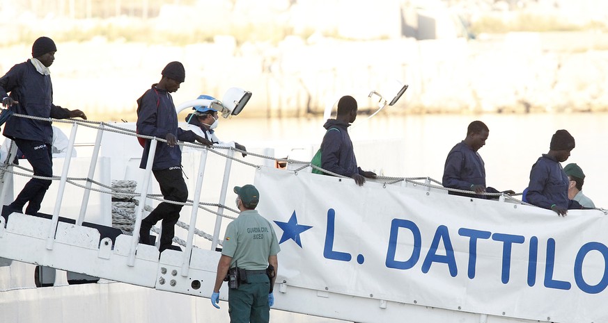 Migrants descend the Italian coast guard vessel Dattilo upon arrival at the eastern port of Valencia, Spain, Sunday, Jun. 17, 2018. The first Italian government ship accompanying the migrant aid vesse ...