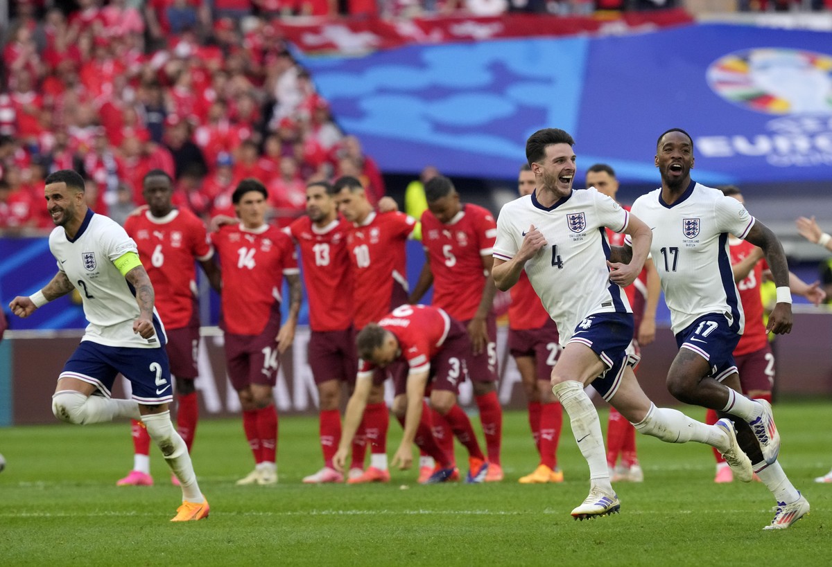 England players celebrate in front of Swiss players after Trent Alexander-Arnold scored the winning goal during the penalty shootout of a quarterfinal match between England and Switzerland at the Euro ...