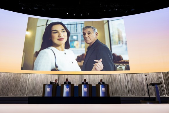 An advertisement featuring Dua Lipa, Nespresso's new global ambassador and George Clooney is displayed on a giant screen front of Philipp Navratil, Chief Executive Officer (CEO) of Nestle, and Pa ...