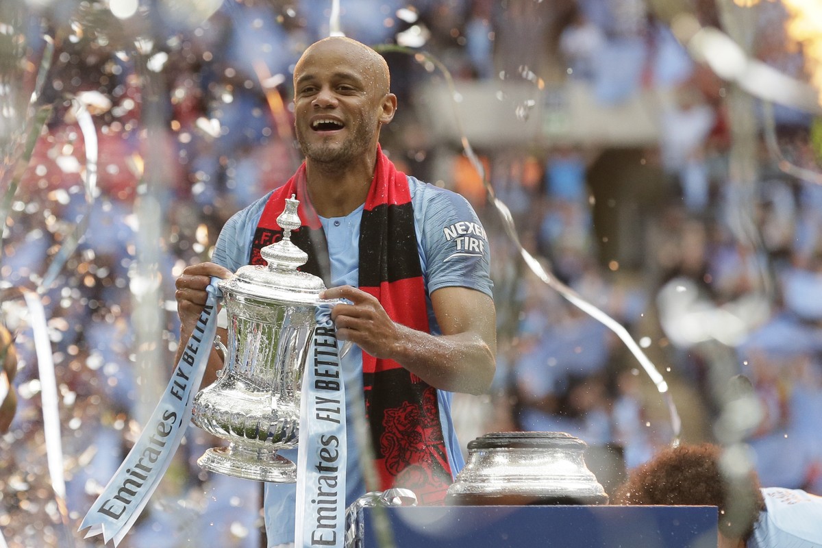 Manchester City's team captain Vincent Kompany lifts the trophy after winning the English FA Cup Final soccer match between Manchester City and Watford at Wembley stadium in London, Saturday, May ...