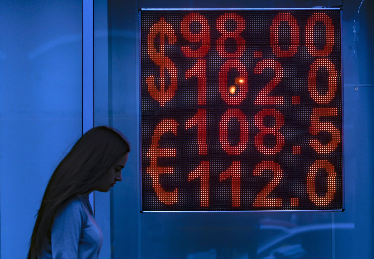 epa10800117 A woman walks past an exchange office with an electronic panel displaying currency exchange rates for US dollar and Euro against Russian ruble in Moscow, Russia, 14 August 2023. The Russia ...
