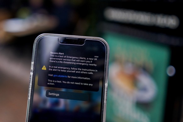 A smartphone displays the banner of an emergency alert system, in London, Sunday, April 23, 2023. The Government sent an alert to all mobile phone users, to test the system which is intended to warn o ...