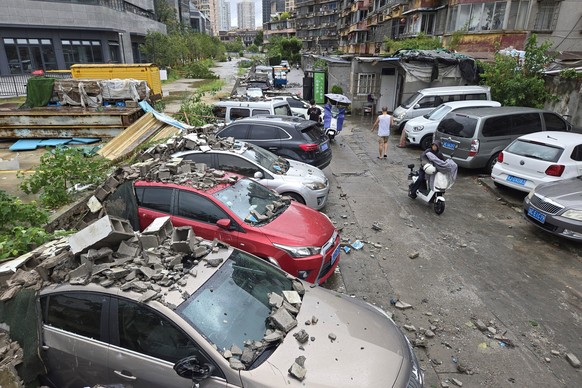 Residents pass by vehicles damaged by a fallen wall in the aftermath of Typhoon Dolphin in Wenzhou in eastern China's Zhejiang province, Monday, Aug. 10, 2026. (Chinatopix via AP)
China Asia Stor ...