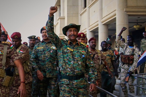FILE - Sudan&#039;s military chief Gen. Abdel-Fattah Burhan, center, is greeted by troops as he arrives at the Republican Palace, recently recaptured from the Rapid Support Forces (RSF) paramilitary g ...
