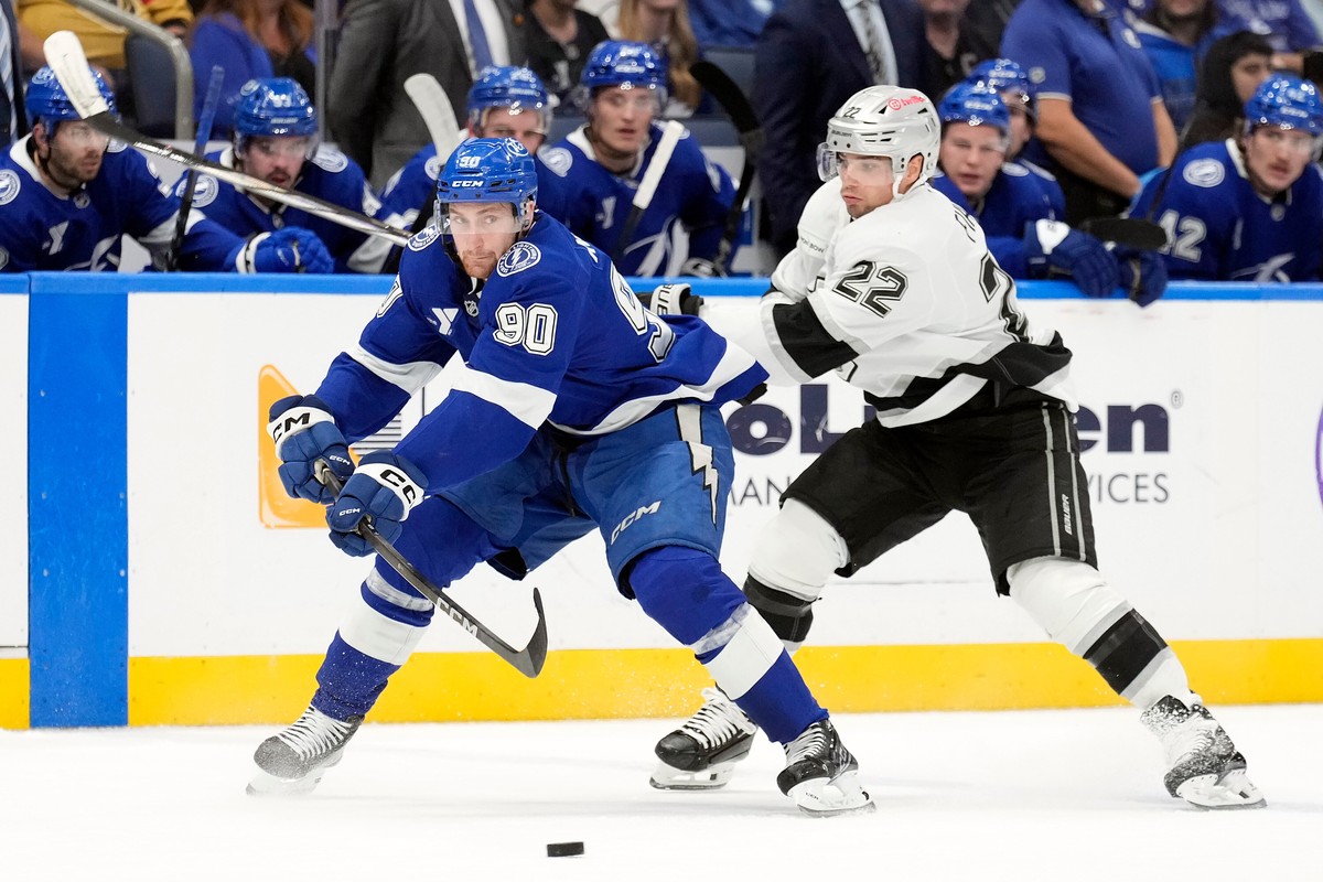 Tampa Bay Lightning defenseman J.J. Moser (90) moves the puck away from Los Angeles Kings left wing Kevin Fiala (22) during the first period of an NHL hockey game Thursday, Dec. 18, 2025, in Tampa, Fl ...