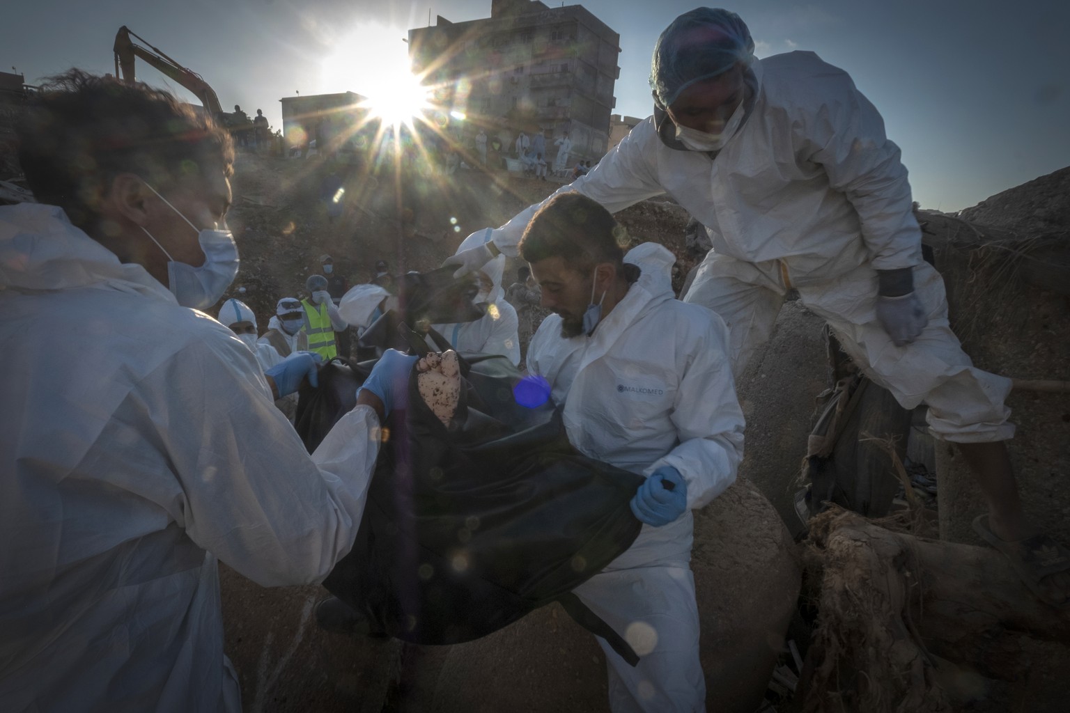Rescuers recover the body of a victim killed during flooding in Derna, Libya, Friday, Sept. 15, 2023. Search teams are combing streets, wrecked buildings, and even the sea to look for bodies in Derna, ...