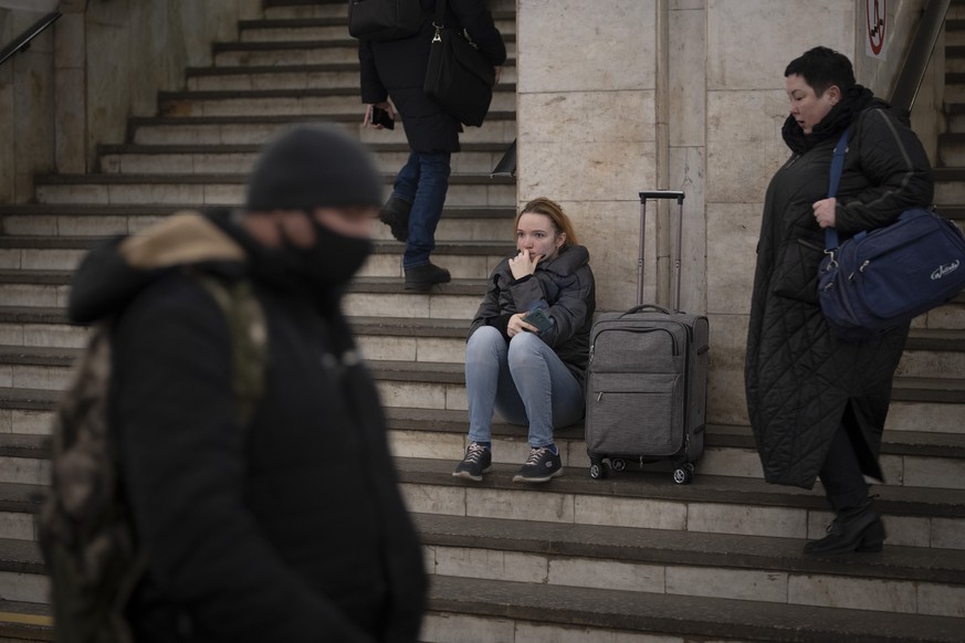 People walk in a subway to get a train as they leave the city of Kyiv, Ukraine, Thursday, Feb. 24, 2022. Russian President Vladimir Putin on Thursday announced a military operation in Ukraine and warn ...