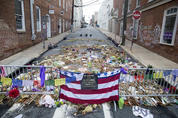 epa06159869 Flowers, candles and other items are placed in memory of Heather Heyer and for those affected by the violence at the site where a vehicle smashed into counter-protesters in Charlottesville ...