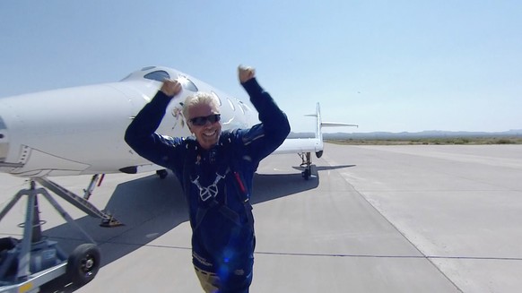 epa09339443 A framegrab from a video courtesy of .Virgin Galatic shows Sir Richard Branson reacting as he steps out of SpaceShip Two Unity 22 shortly after landing in a space-to-space return…