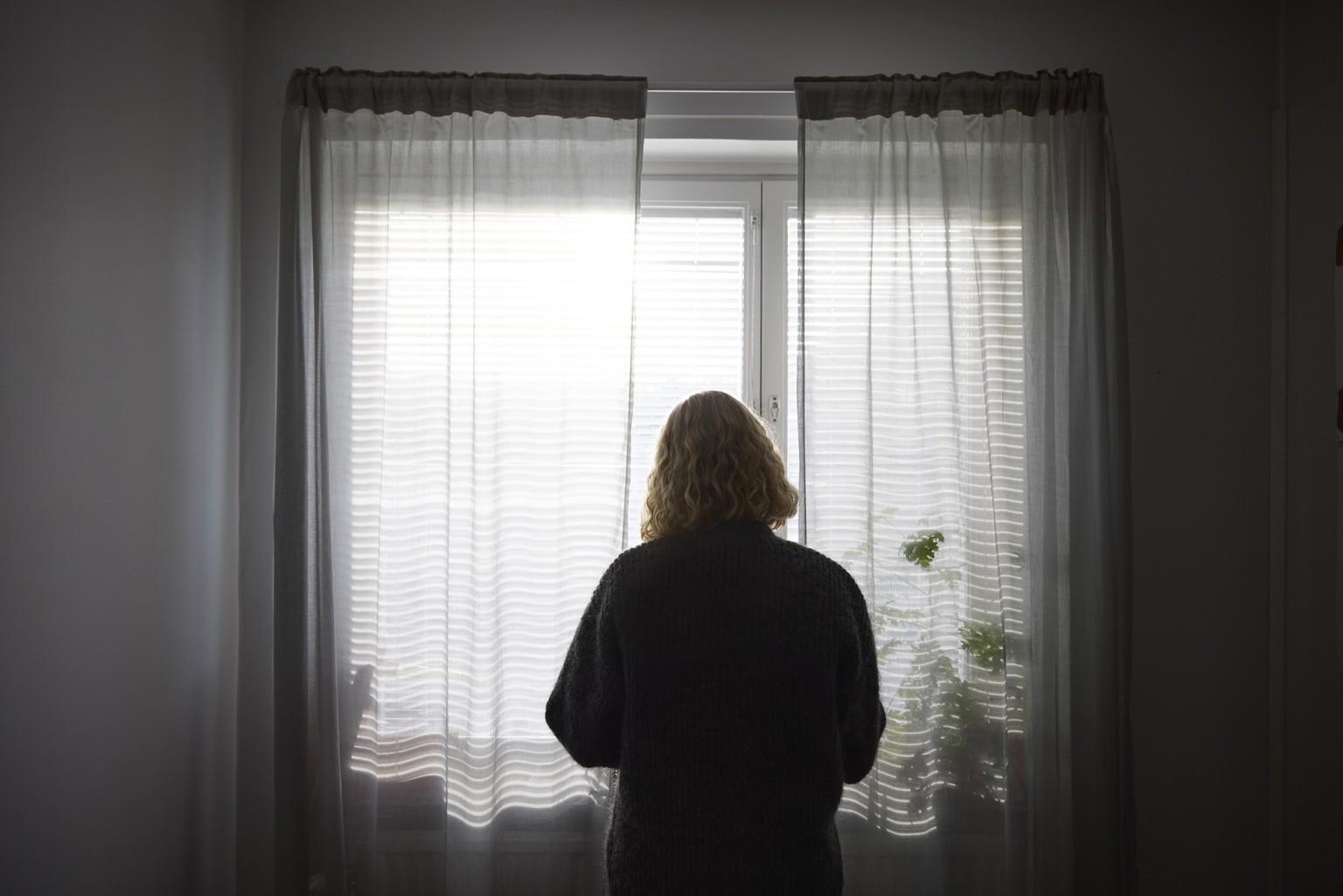 Rear view of teenage girl looking through window