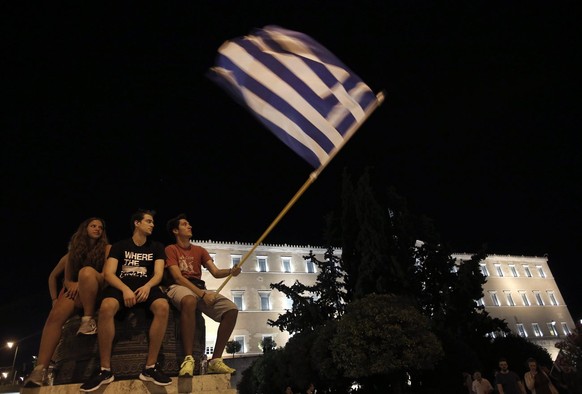 epa04832875 Supporters of the &#039;No&#039; campaign wave flags and react after the first results of the referendum at Syntagma Square, in Athens, Greece, 05 July 2015. Greek voters in the referendum ...