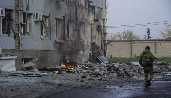 epa10264093 A Russian serviceman walks at the site of a car explosion near the &#039;ZaTV&#039; broadcaster building in Melitopol, Zaporizhzhia region, southeastern Ukraine, 25 October 2022. At least  ...