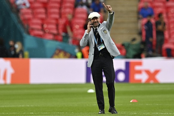 Italy delegation chief Gianluca Vialli gestures while walking on the pitch prior the start of the Euro 2020 soccer championship final match between England and Italy at Wembley Stadium in London, Sund ...