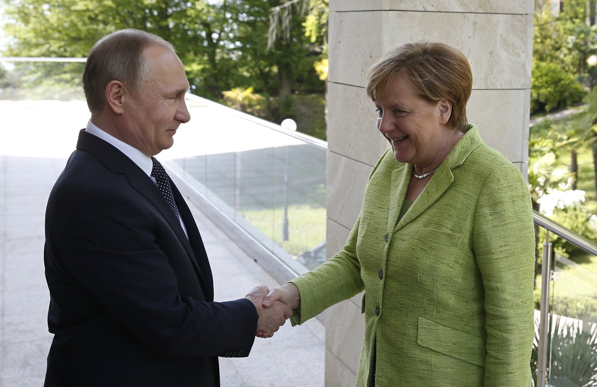 Russian President Vladimir Putin, left, and German Chancellor Angela Merkel shake hands prior to their talks at Putin's residence in the Russian Black Sea resort of Sochi, Russia, Tuesday, May 2, ...