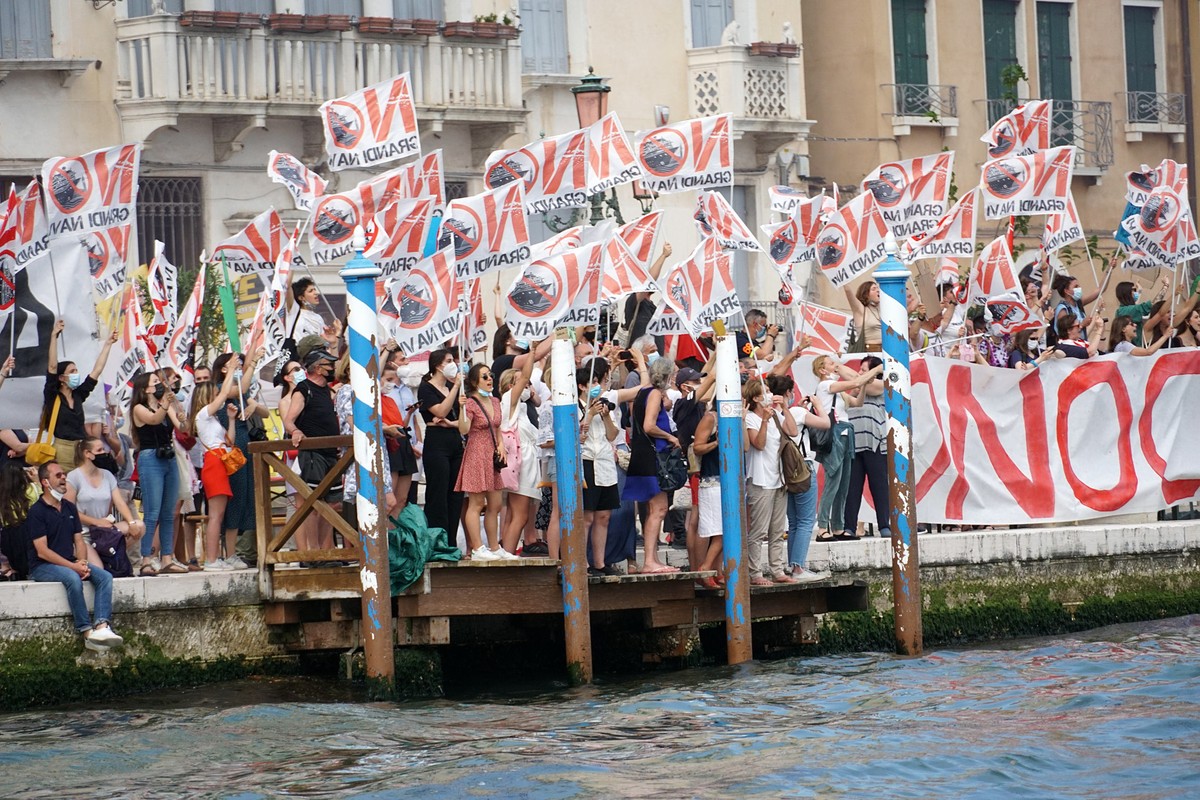 epa09249824 Activists of the committee 'No Grandi Navi' (No big ships), wave flags as they protest against the MSC Orchestra cruise ship being allowed in the Lagoon, during the navigation of ...