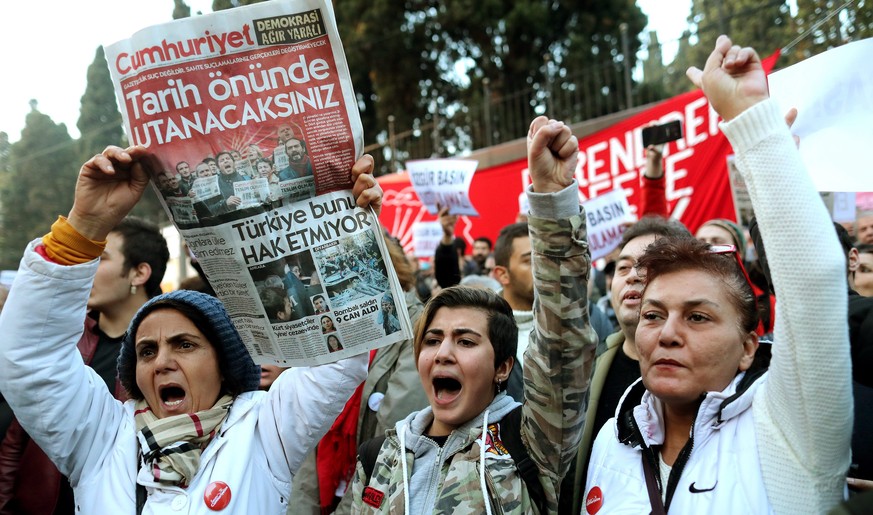 epa05618876 People chant slogans as they hold a copy of today&#039;s edition of Cumhuriyet newspaper in front of the headquarters of Cumhuriyet daily newspaper in Istanbul, Turkey, 05 November 2016. T ...