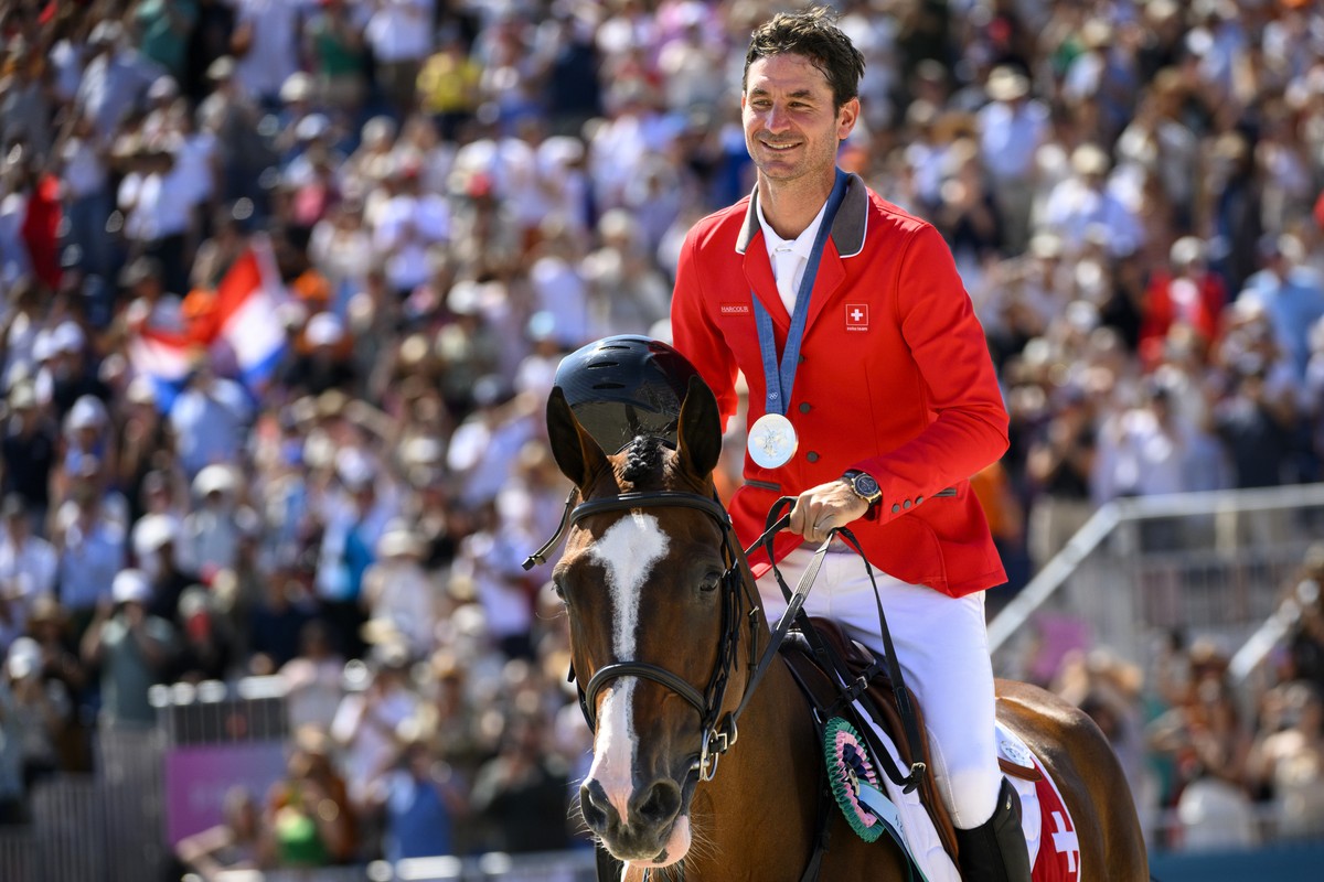 Silver medalist Steve Guerdat of Switzerland riding Dynamix De Belheme celebrates after the victory cermony of the equestrian individual finals at the 2024 Paris Summer Olympics in Paris, France, Tues ...