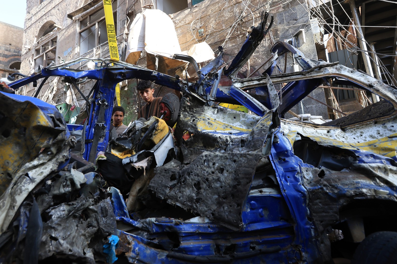 epaselect epa12043882 People inspect damaged vehicles after an air strike in Sana'a, Yemen, 21 April 2025. At least 12 people were killed, and 30 others wounded in a US raid which struck a neighb ...