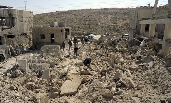 In this photo released by the Syrian official news agency SANA, people inspect damage after an Israeli airstrike near Damascus, Syria, Monday, March 7, 2022. Israel fired several missiles toward Syria ...