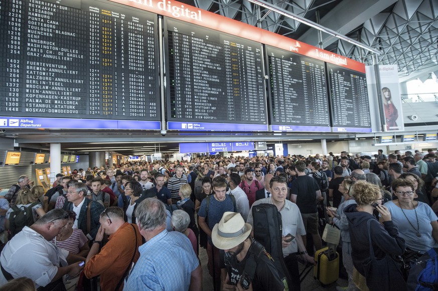 Passengers wait in a hall of terminal 1 of the Frankfurt, Germany, Airport, Tuesday, Aug. 7, 2018 after parts of a terminal were evaucated over concerns that at least one person may have entered the f ...