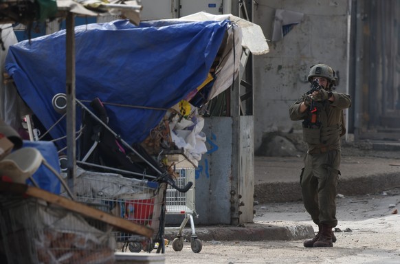 epa11900815 An Israeli soldier aims his weapon during an Israeli military operation in the West Bank city of Nablus, 16 February 2025. At least 20 people have been wounded in the Israeli raid, the Pal ...