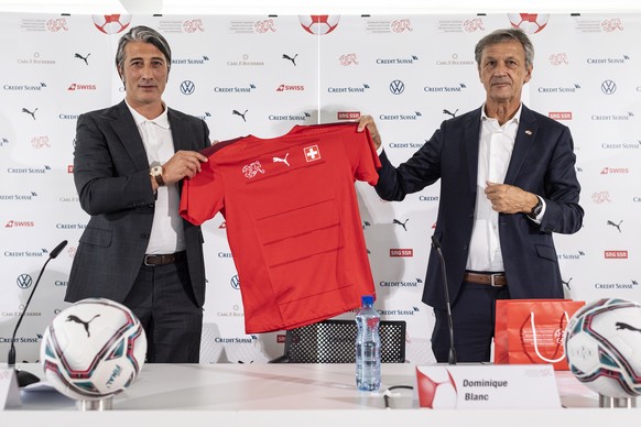 epa09407349 Swiss soccer coach Murat Yakin (L) holds a shirt of the Swiss national soccer team next to Dominique Blanc, president of the Swiss football federation SFV, at a press conference where he i ...