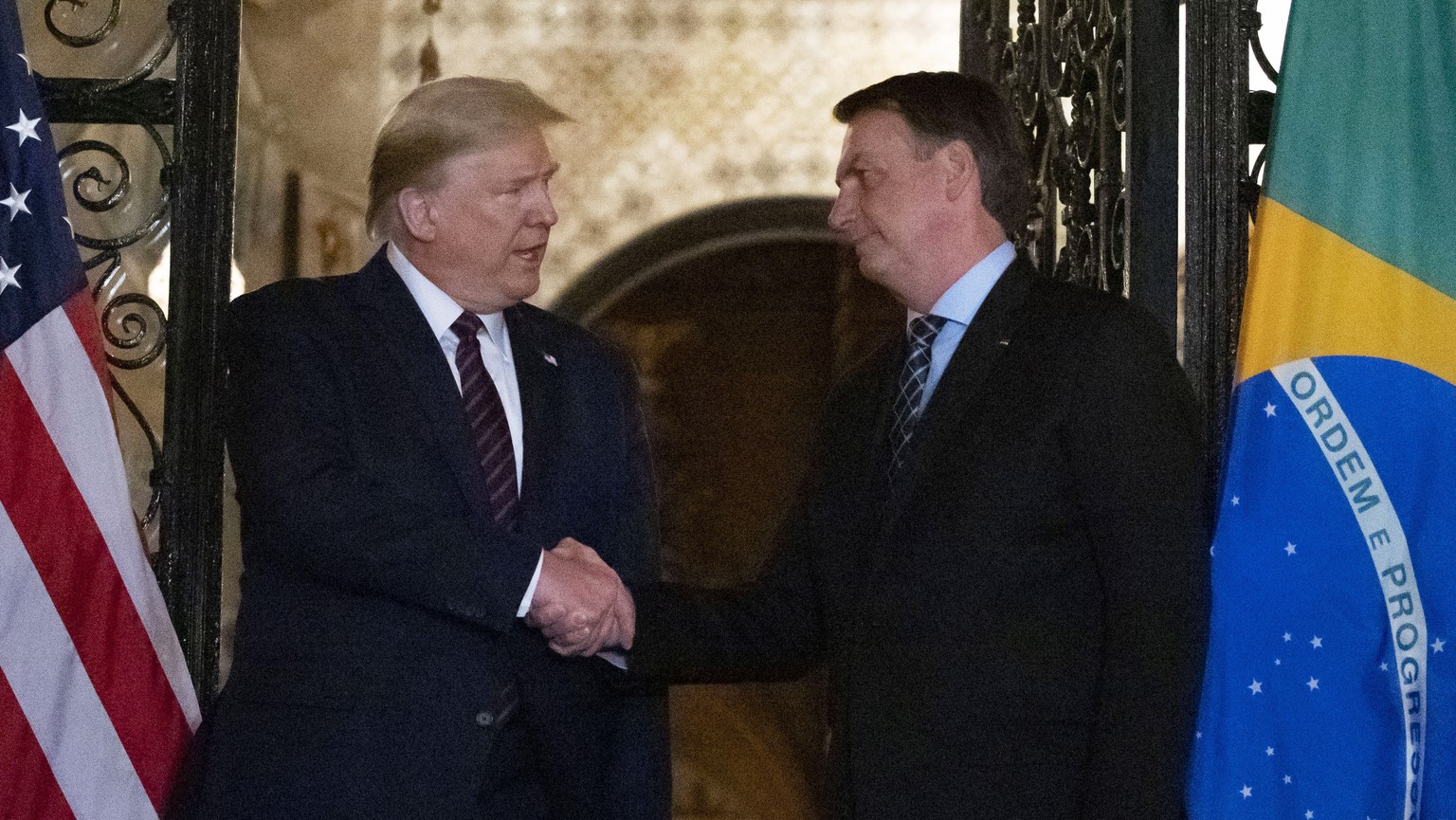 FILE - In this March 7, 2020, file photo President Donald Trump shakes hands before a dinner with Brazilian President Jair Bolsonaro at Mar-a-Lago in Palm Beach, Fla. BolsonaroÄôs communications dire ...