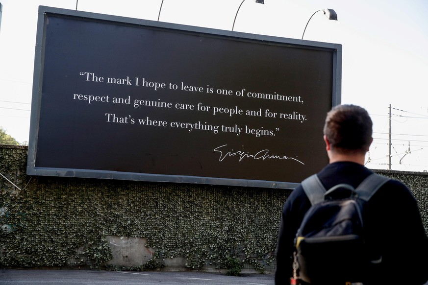 epa12356376 A person looks at a billboard at Giorgio Armani&#039;s funeral chapel on Via Bergognone, Milan, Italy, 06 September 2025. The atelier houses the designer&#039;s funeral chapel. Armani has  ...
