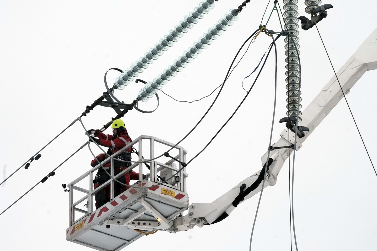epa11882546 Specialists cut a loop of power line next to the border of Russia, Latvia, 08 February 2025. The Baltic states of Lithuania, Latvia, and Estonia on 08 February cut ties with Russia's  ...