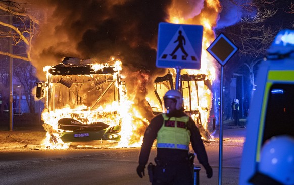 epaselect epa09894066 Riot police on site while a city bus burns on Vastra Kattarpsvagen on Rosengard in Malmo, Sweden, 17 April 2022. The unrest in Malmo has continued after Rasmus Paludan, party lea ...