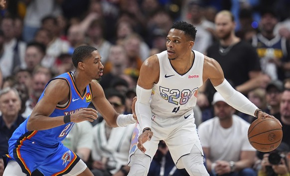 Denver Nuggets guard Russell Westbrook, right, looks to pass the ball as Oklahoma City Thunder guard Aaron Wiggins defends in the second half of Game 6 in the Western Conference semifinals of the NBA  ...