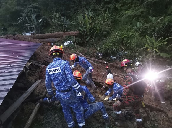 In this photo provided by Civil Defense Department, Civil Defense personnel search for survivors buried after a landslide hit a campsite in Batang Kali, Malaysia, Friday, Dec. 16, 2022. A landslide hi ...