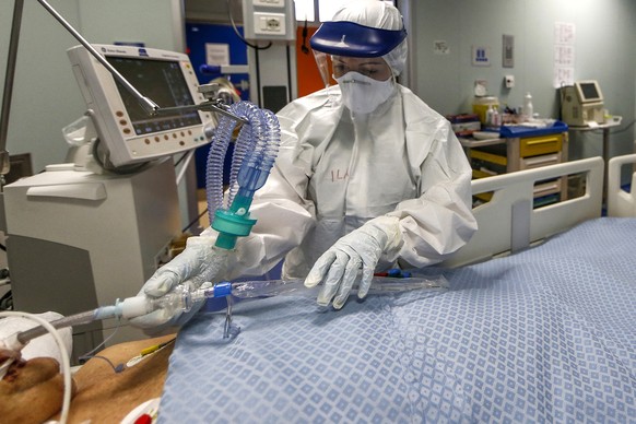 A medical staffer tends to a patient in the ICU unit of the Covid 3 hospital in Casalpalocco, near Rome, Saturday, April 11, 2020. Italy has topped 19,000 deaths and 150,000 cases of coronavirus. The milestones were hit Saturday, even as the country continued to see a slight decrease in numbers of people hospitalize and in intensive care. The new coronavirus causes mild or moderate symptoms for most people, but for some, especially older adults and people with existing health problems, it can cause more severe illness or death. (Cecilia Fabiano/LaPresse via AP)
