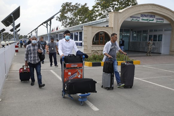 Passengers walk from the domestic terminal at Hamid Karzai International Airport in Kabul, Afghanistan, Saturday, Aug. 14, 2021. As a Taliban offensive encircles the Afghan capital, there&#039;s incre ...