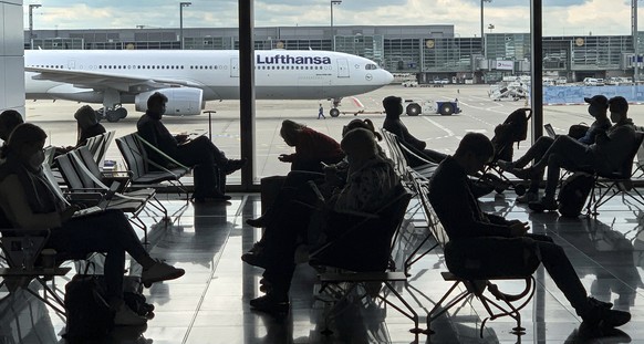 FILE -Passengers wait for their Lufthansa flight at the airport in Frankfurt, Germany, Saturday, May 15, 2021. The number of air passengers in Germany rebounded somewhat in 2021, but was still over tw ...