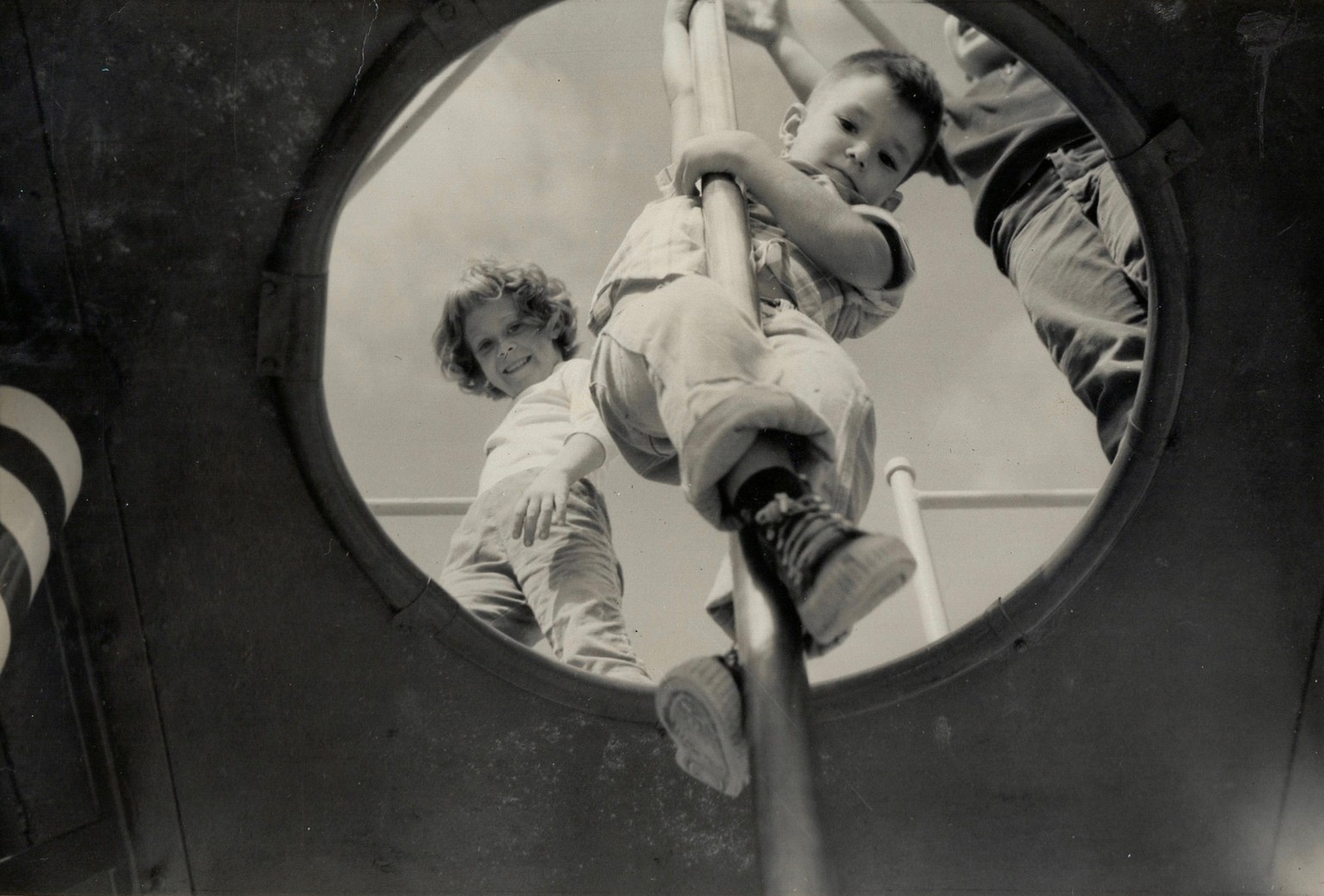 View, from below, as a young boy slides down fireman&#039;s pole at a playground, Florida, 1958. A girl watches from above. (Photo by The Harrington Family Collection/Getty Images)