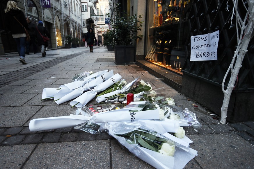 epa07226057 Candles, flowers and a sign reading &#039;All united against barbarity&#039; are left where a person was killed during the Christmas Market shooting in Strasbourg, France, 12 December 2018 ...