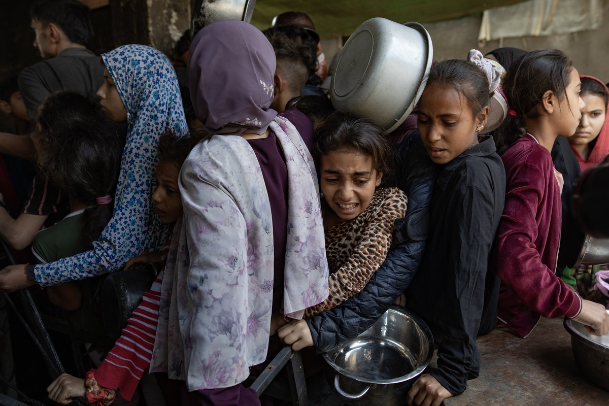 epa12122619 Hundreds of displaced Palestinians gather outside the Sokar Charity Kitchen in Gaza City to receive limited food rations,21 May, 2025. Kitchen officials say their stocks ran out today due  ...