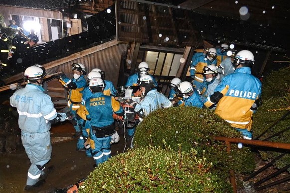epa11061773 This handout picture provided by Metropolitan Police Department via Jiji Press shows police officers rescuing a woman in her 90s at a collapsed house five days after a powerful earthquake  ...