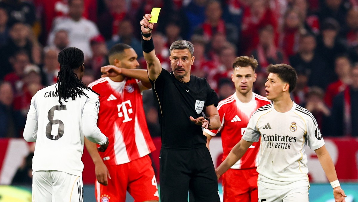 epa12892614 Referee Slavko Vincic (C) shows yellow card to Eduardo Camavinga (L) of Real Madrid during the UEFA Champions League quarter-finals, 2nd leg match FC Bayern Munich against Real Madrid, in  ...