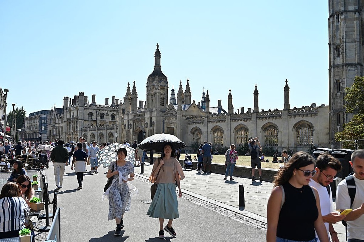 CAMBRIDGE, ENGLAND - AUGUST 17: People walk past the King's College as people dine at a cafe on the King's Parade on August 17, 2025 in Cambridge, United Kingdom. (Photo by John Keeble/Getty ...