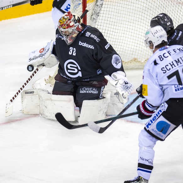 Sandro Schmid (HCFG), centre, lutte pour le puck avec Tim Berni (GSHC), droite, devant le gardien Antti Raanta (GSHC), gauche, lors du match du championnat suisse de hockey sur glace de National Leagu ...