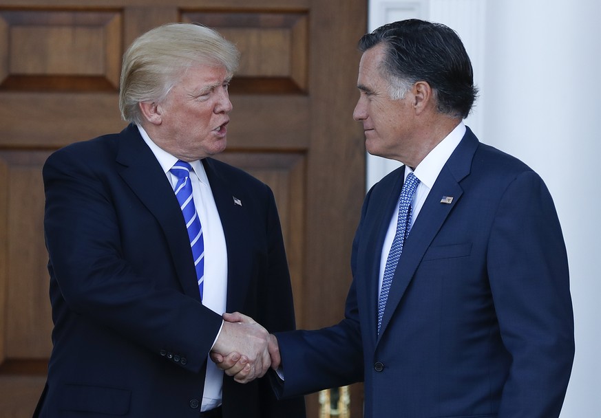 FILE - In this Nov. 19, 2016, file photo, President-elect Donald Trump and Mitt Romney shake hands as Romney leaves the Trump National Golf Club Bedminster in Bedminster, N.J. Romney and Trump exchang ...