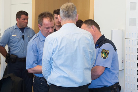 epa05337153 One of the two accused perpetrators (C) in the case of the murder of 17-year-old Annelie in the courtroom at the start of the trial in the district court in Dresden, Germany, 30 May 2016.  ...