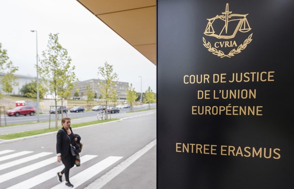 FILE - In this photo taken on Oct. 5, 2015 a woman walks by the entrance to the European Court of Justice in Luxembourg. The European Union���s top court says Google has to delete search results about ...
