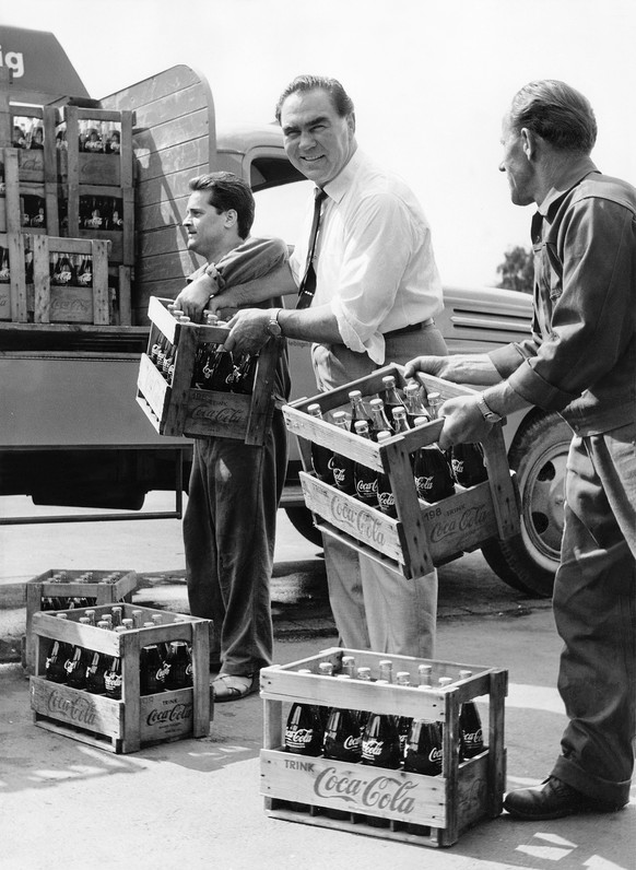 Boxlegende Max Schmeling hilft an diesen heissen Sommertagen persoenlich beim Beladen eines Lieferwagens mit Coca-Cola Harassen mit, aufgenommen am 6. Juni 1961 in Hamburg. Schmeling hat die Vertretun ...
