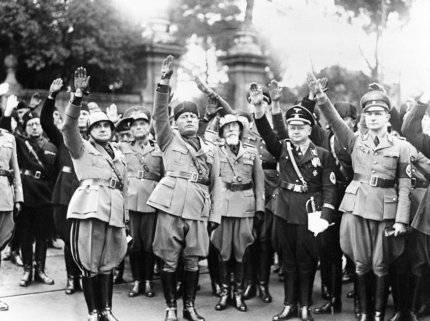 FILE - This Oct. 28, 1936 file photo shows Benito Mussolini, second from left, flanked by Nazis officers on the occasion of the celebration of the fourteenth anniversary of Italian Fascism. Not since Benito Mussolini’s ignominious fall after failed attempts at making Italy a colonial power that gave Hitler the upper hand in their axis, has the executed former dictator’s image carried such currency. (AP Photo, File)