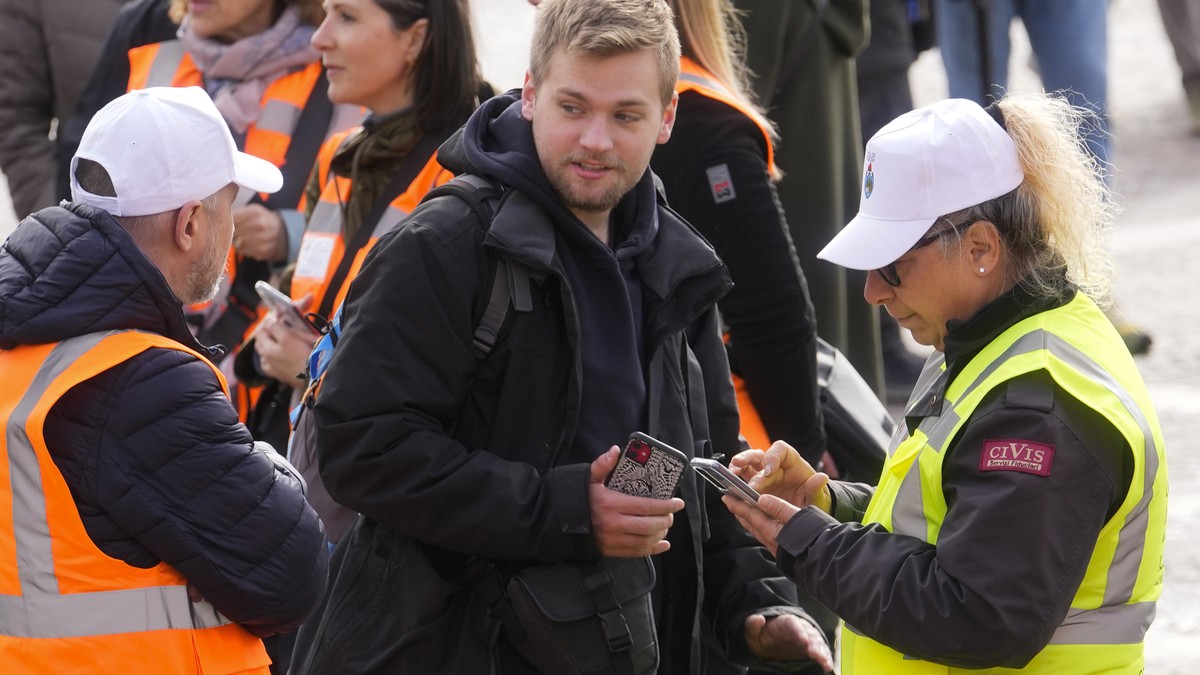 Stewards check a tourist QR code access outside the main train station in Venice, Italy, Thursday, April 25, 2024. The fragile lagoon city of Venice begins a pilot program Thursday to charge daytrippe ...