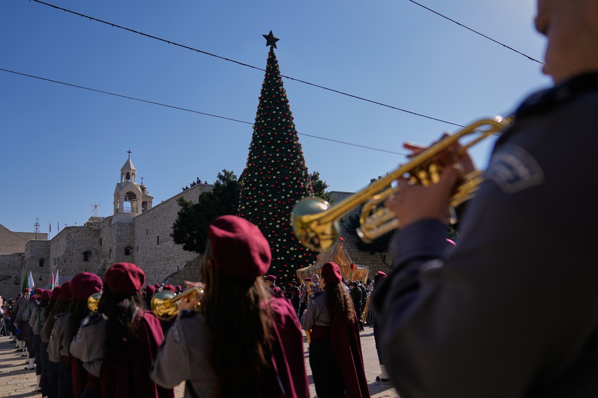 Palestinian scout bands parade at the Manger Square near the Church of the Nativity, traditionally believed to be the birthplace of Jesus, on Christmas Eve, in the West Bank city of Bethlehem, Wednesd ...